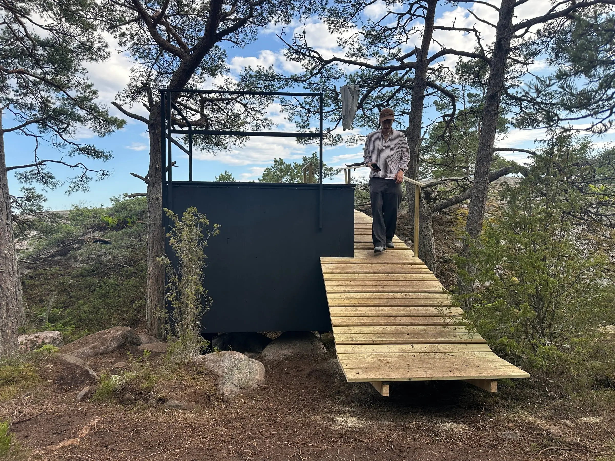 A person walking down the bridge from the shelter roof