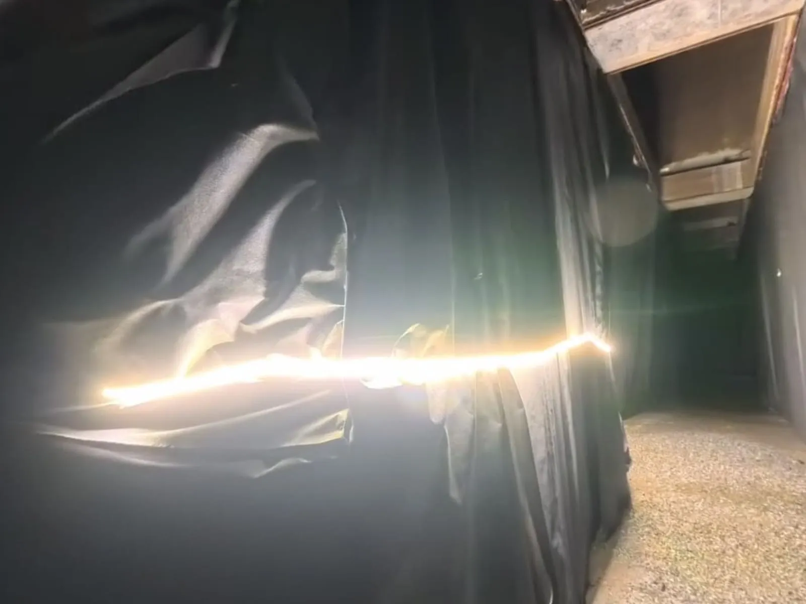Light strip running along hung black fabric