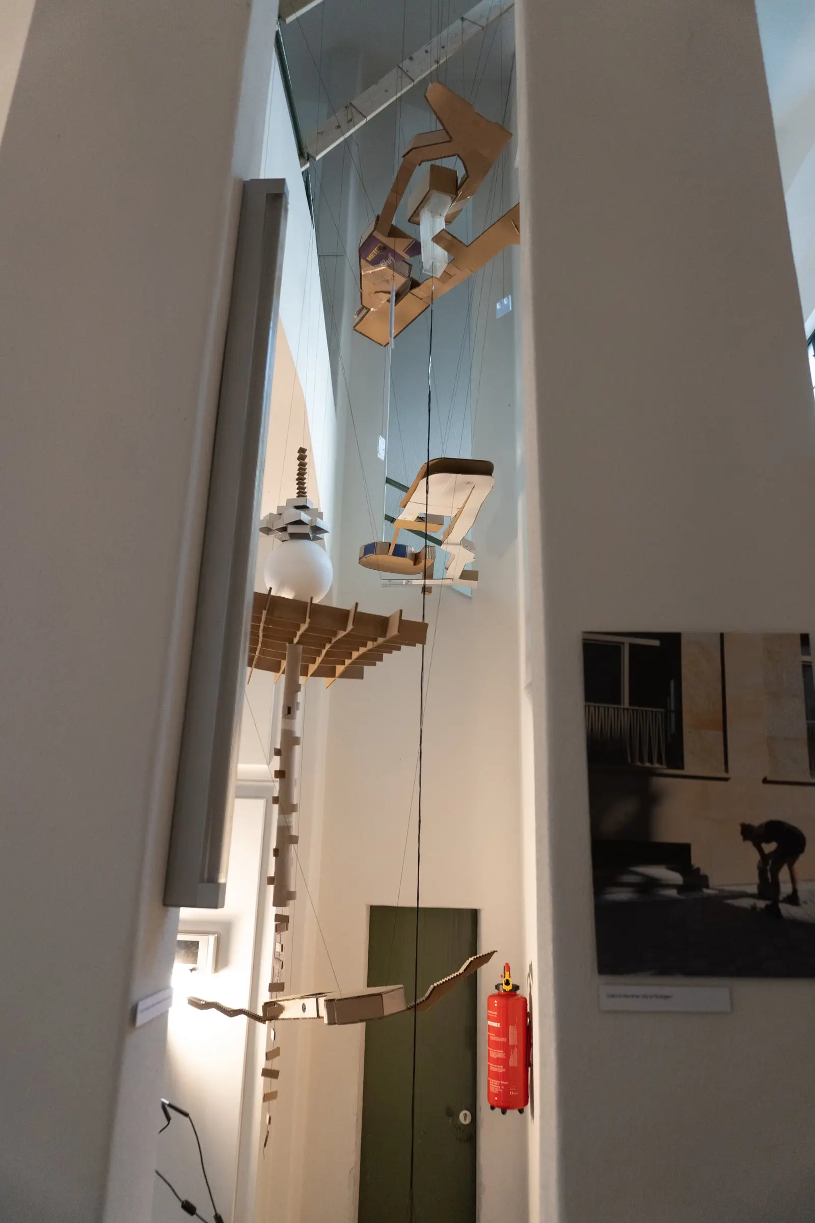 The model seen from below, running the full height of the stairwell past a fire extinguisher and a green door