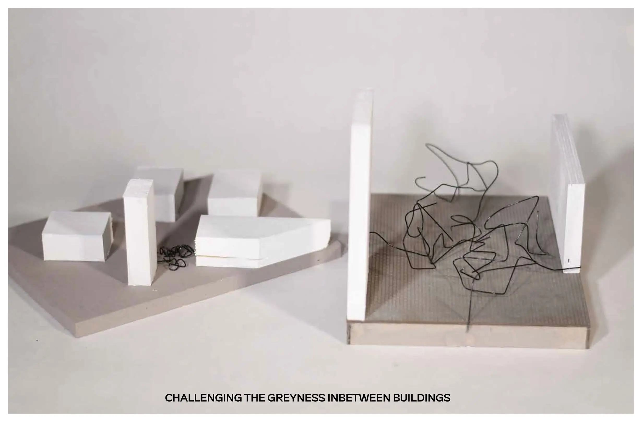 White model blocks beside a square base filled with tangled black wire between two white walls