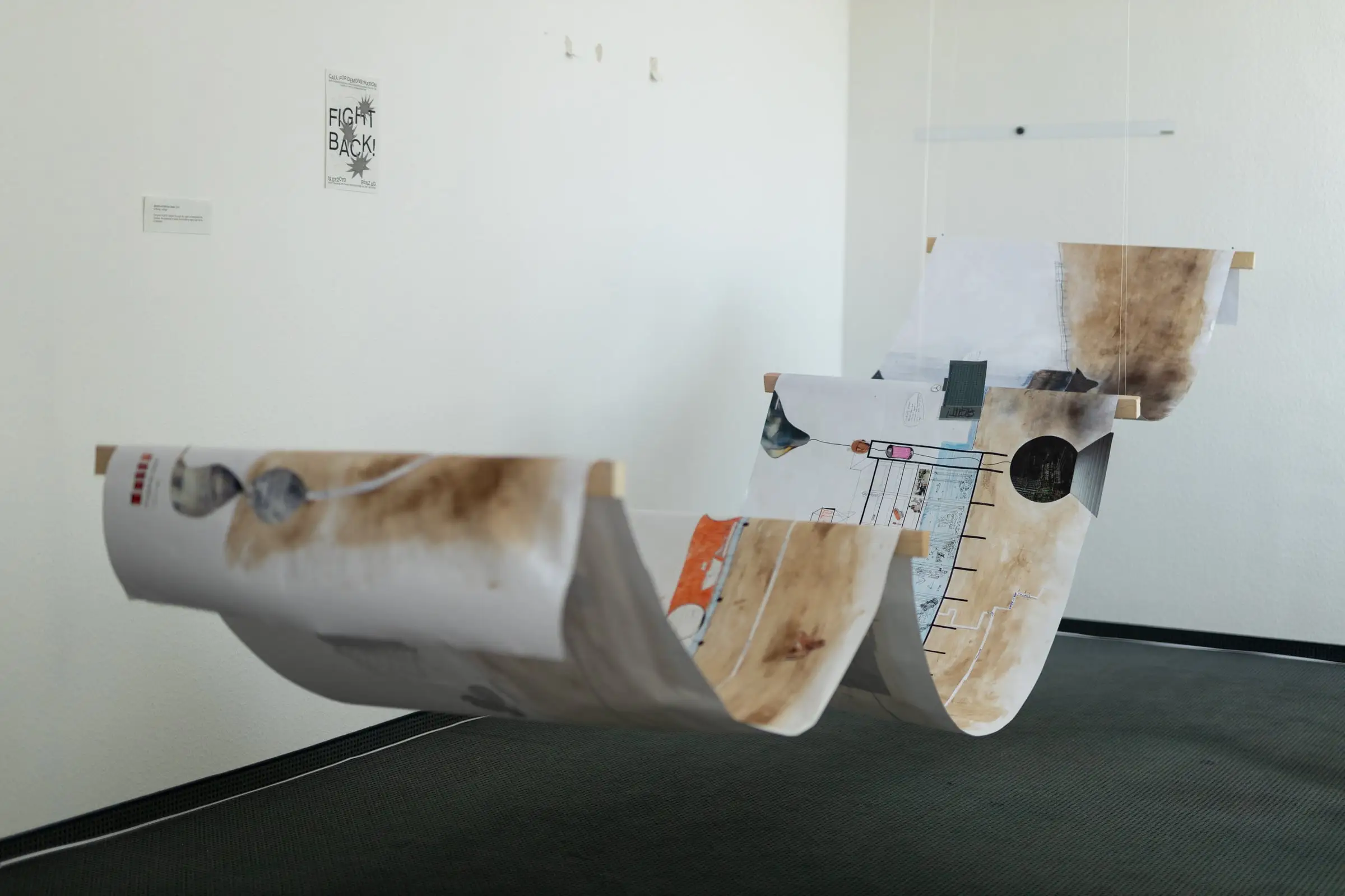 A long paper section hung in waves from the ceiling of a white exhibition room