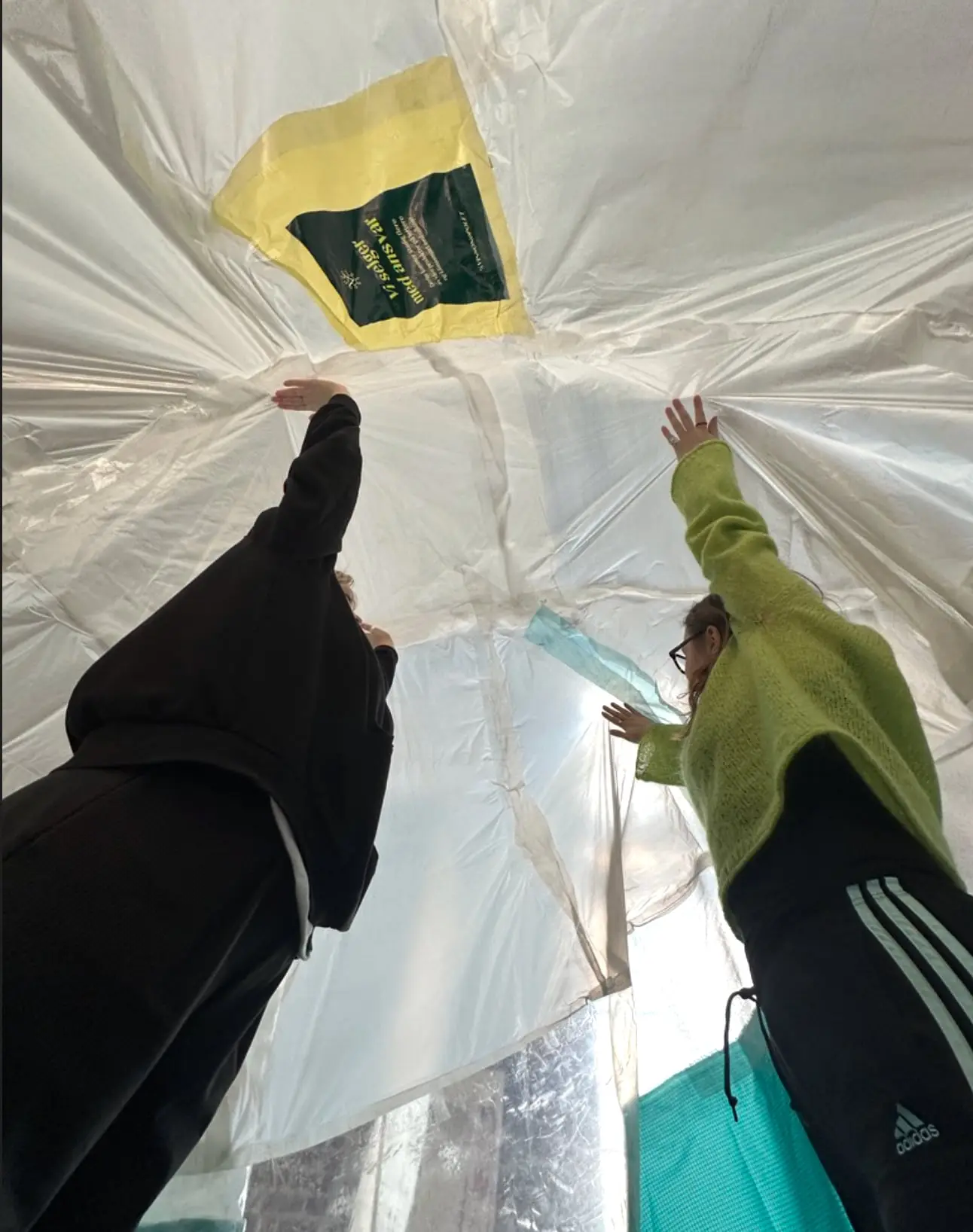 Looking up inside the inflatable as two people hold up the fabric with their hands