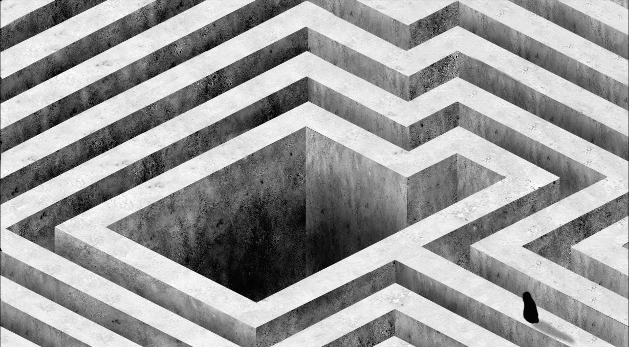 Top-down view into a grey concrete labyrinth with a deep square shaft at its centre and one small figure