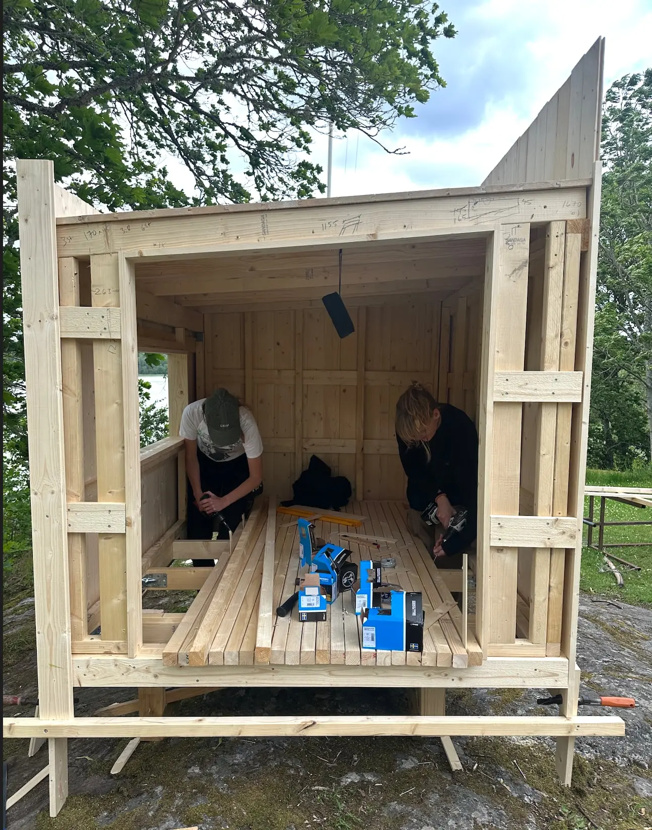 Students inside a full-size timber mock-up of the shelter, laid out with blue model parts