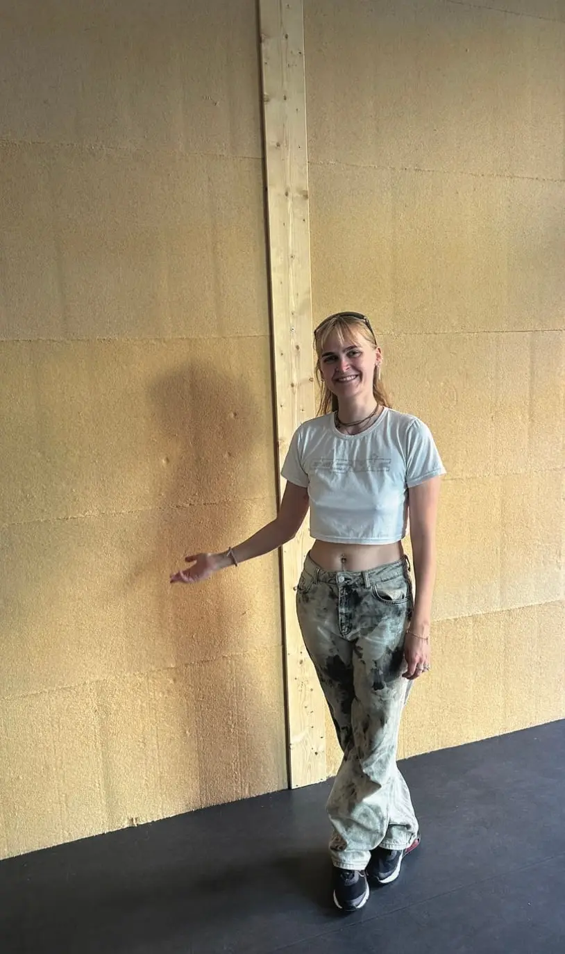 Frida standing in front of a finished wall of insulation boards