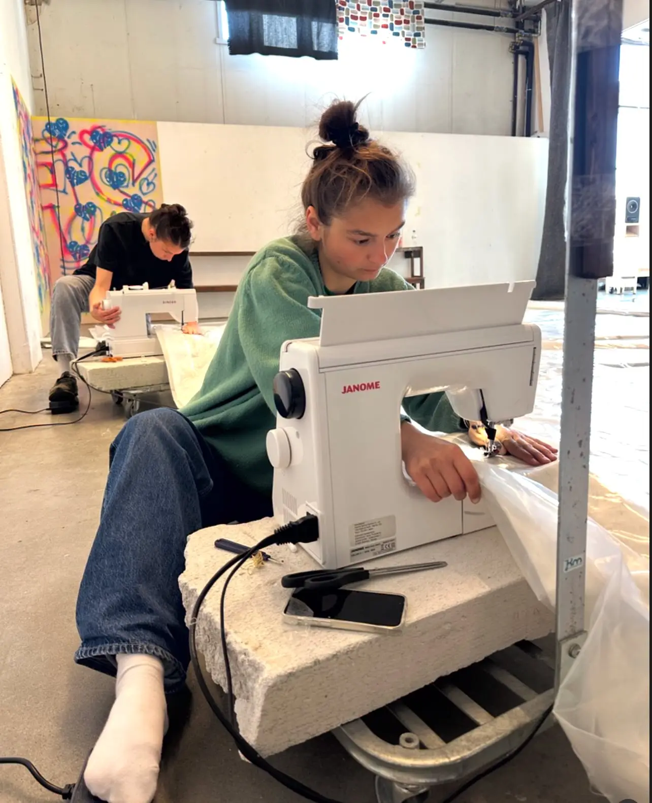 Frida sewing sail fabric at a sewing machine on the workshop floor