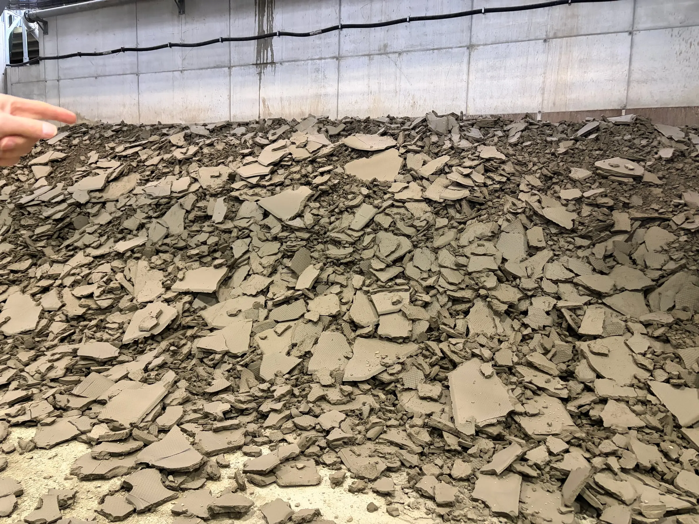 A heap of grey, cracked slabs of polluted material in a hall inside the mountain