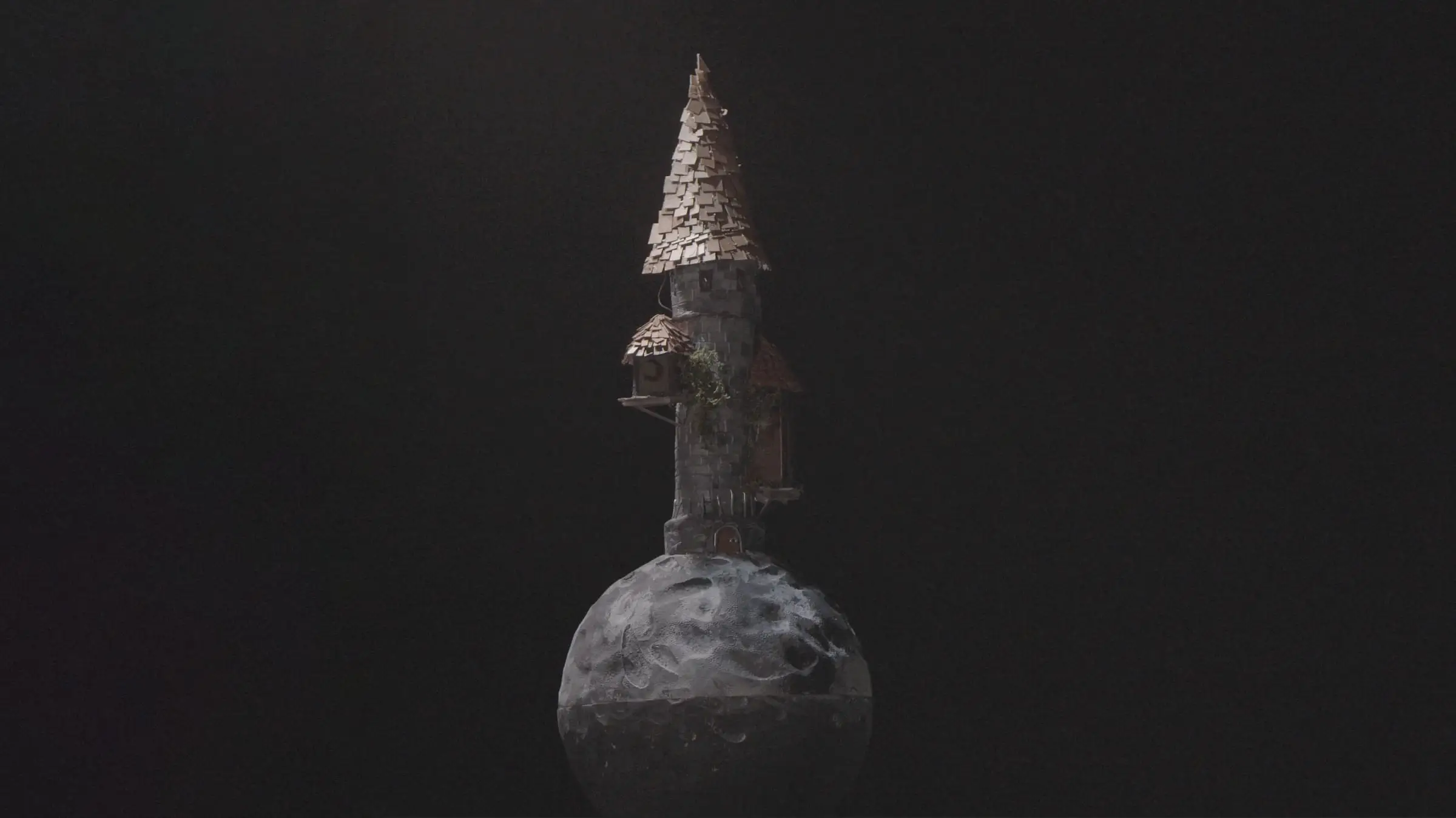 A miniature crooked tower balanced on a small moon, against a black background